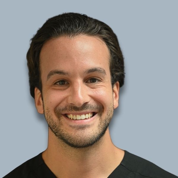 A man in a suit and white shirt is smiling for the camera