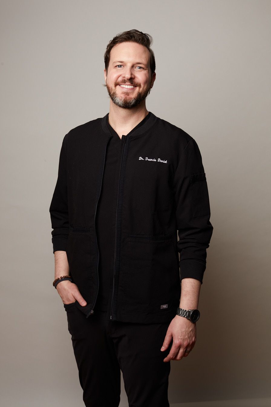A man in a suit and white shirt is smiling for the camera