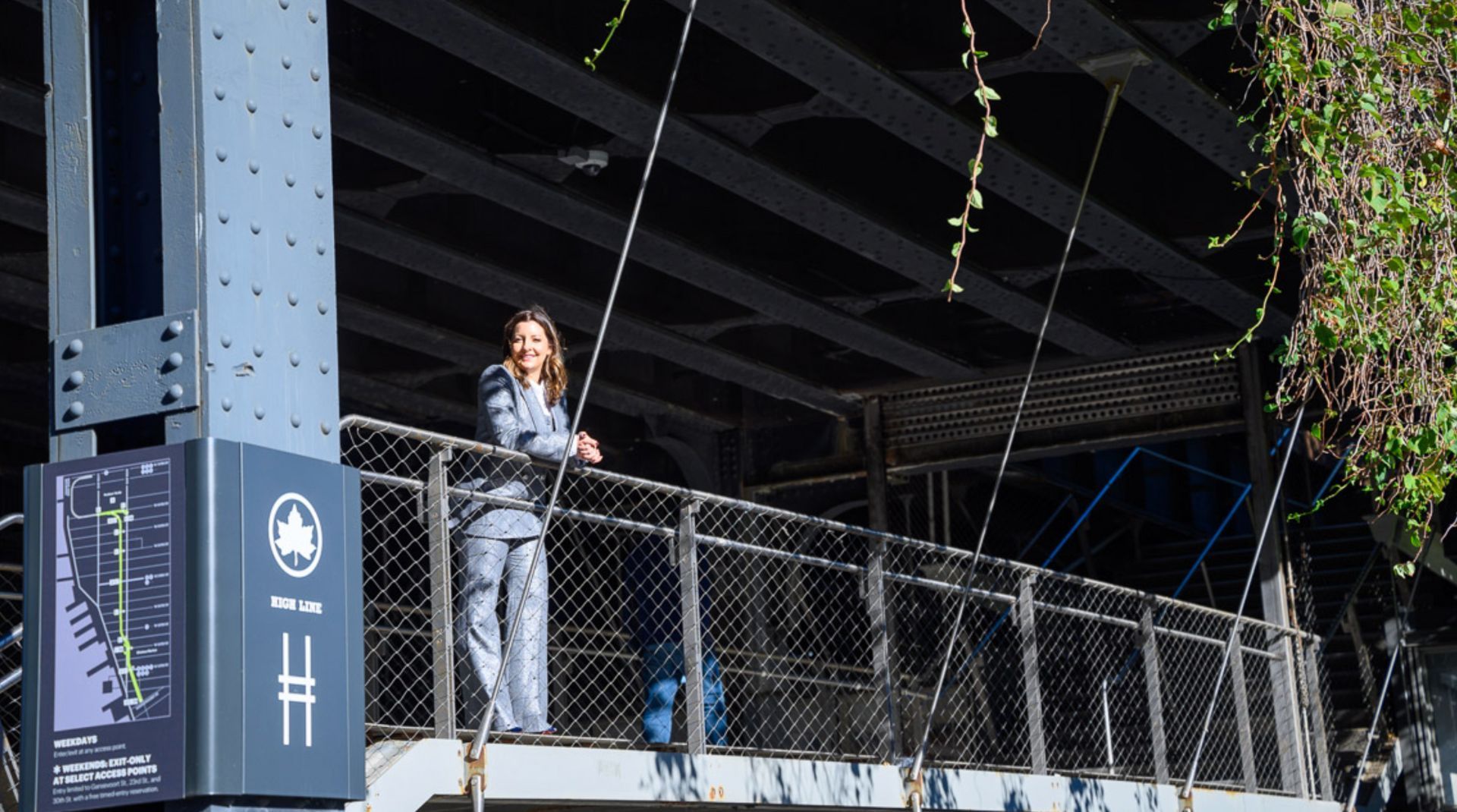 Dr. Elena Johnston standing confidently on the High Line in Chelsea, NYC, wearing a tailored suit—re