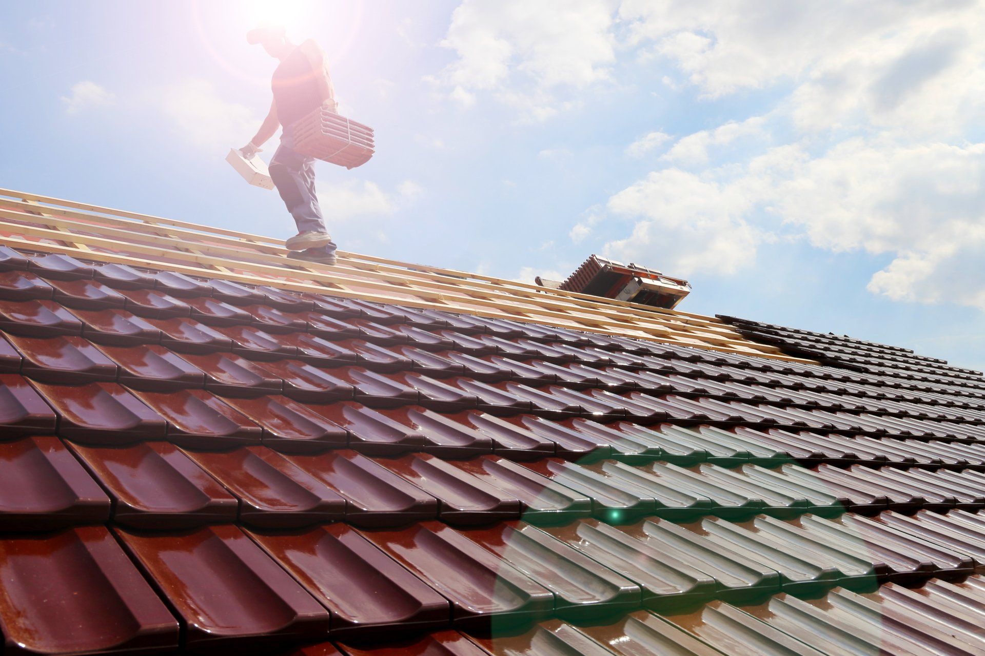 A man is standing on top of a tiled roof.