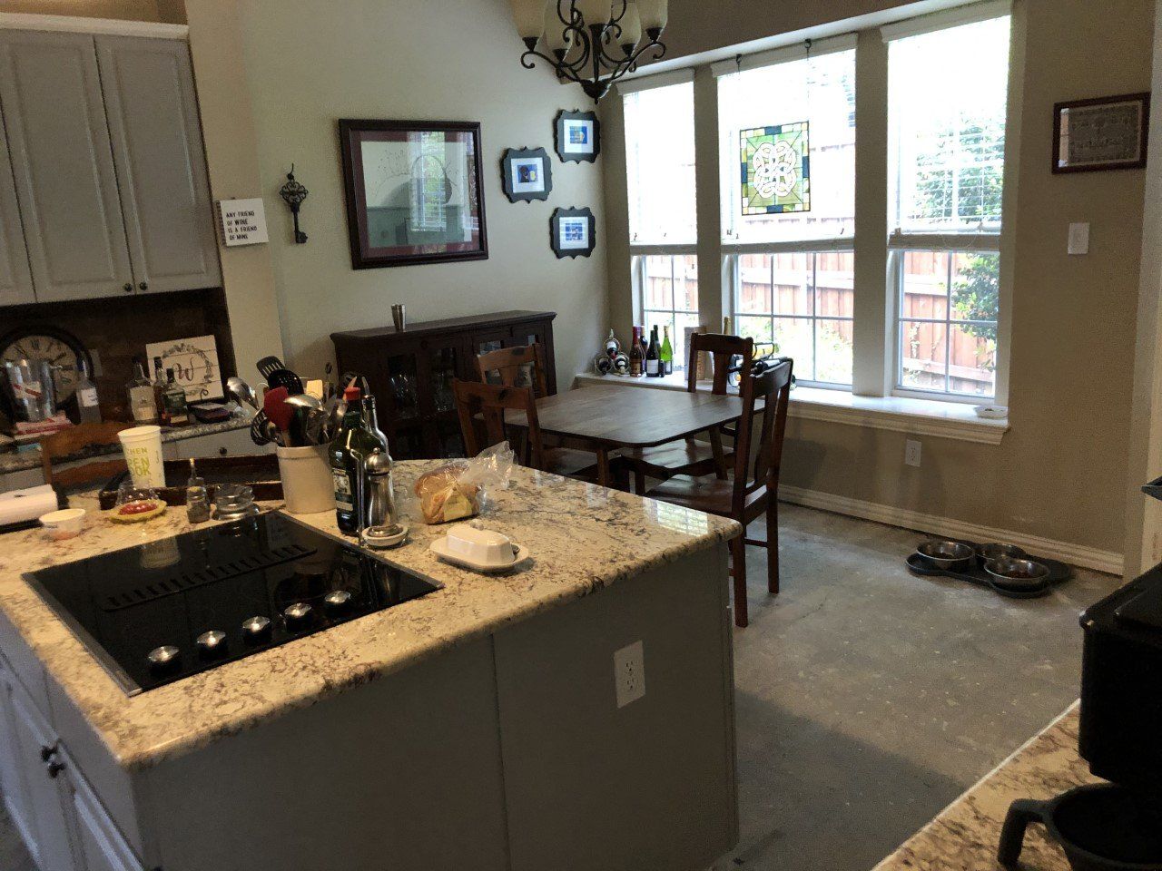 A kitchen with a stove top oven , a table and chairs.