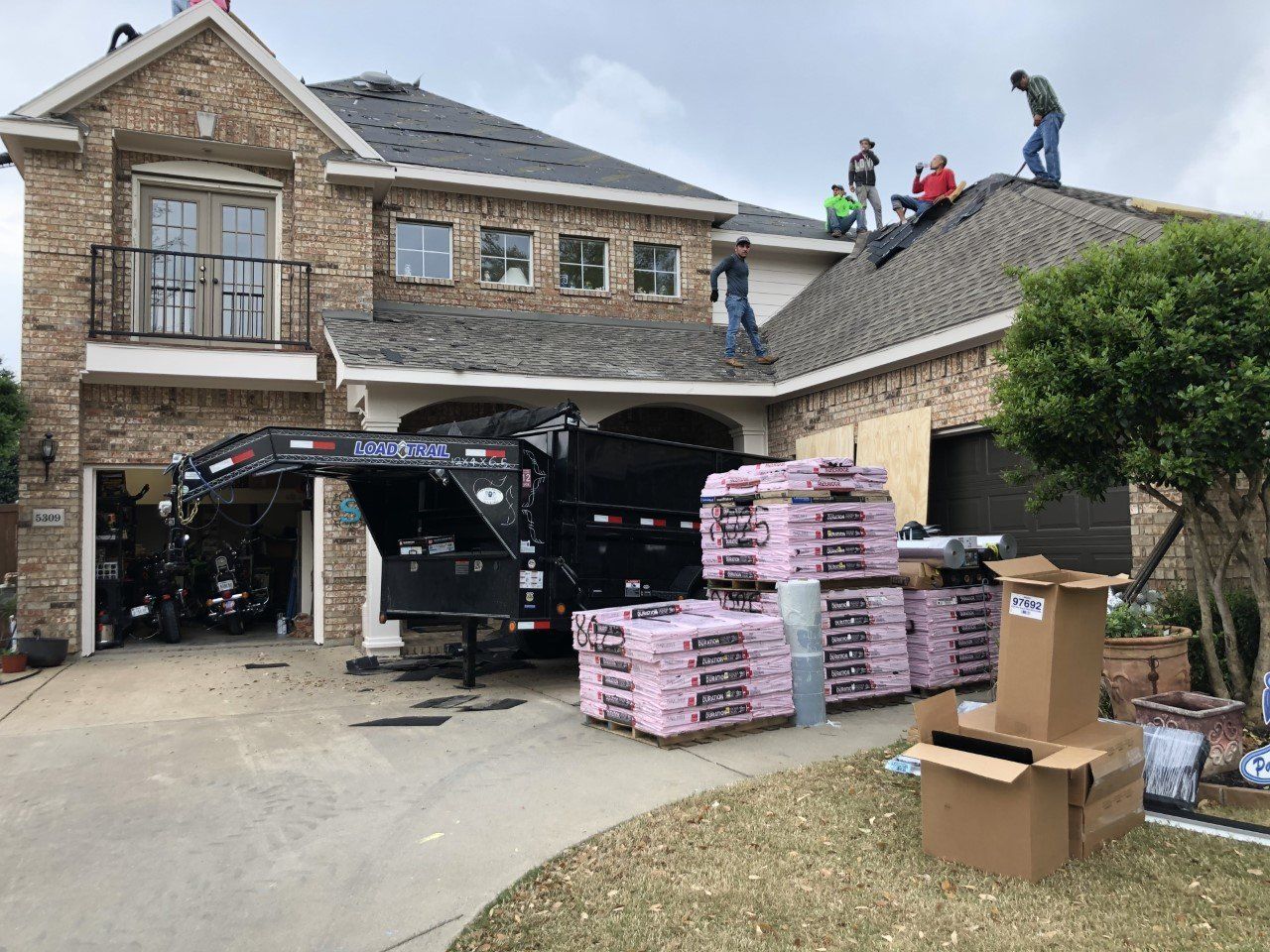 A large brick house with a trailer parked in front of it.