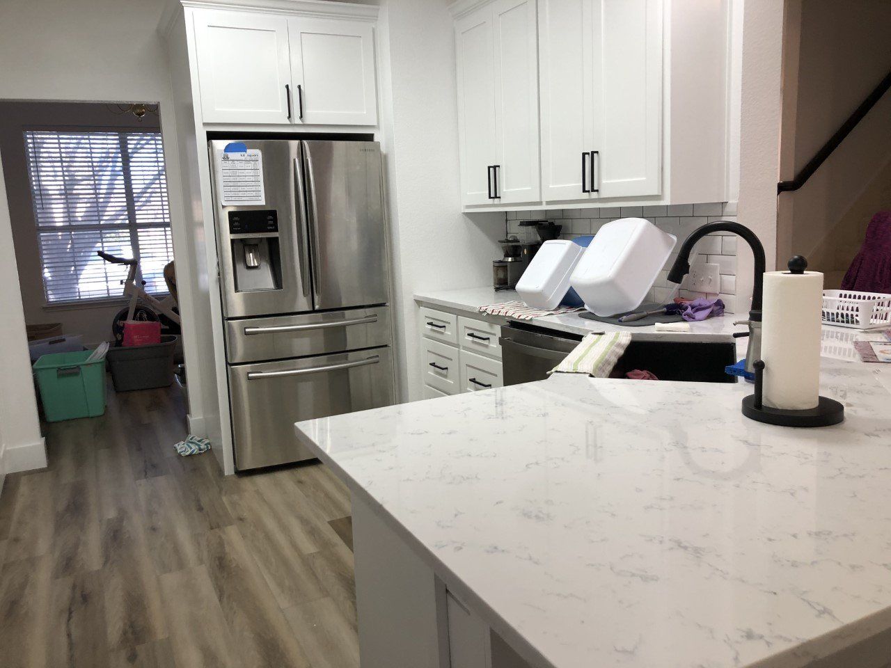 A kitchen with stainless steel appliances and white cabinets.