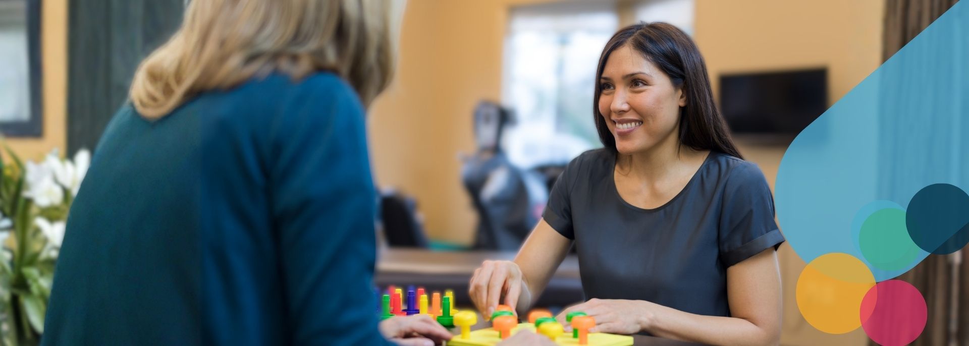 A nurse with a stethoscope around her neck is smiling while standing in front of a building.
