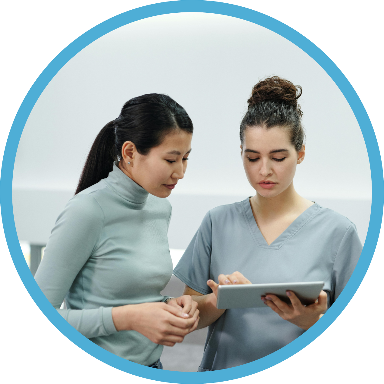 Two women are looking at a tablet together.