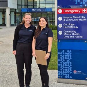 Two women standing in front of an emergency sign