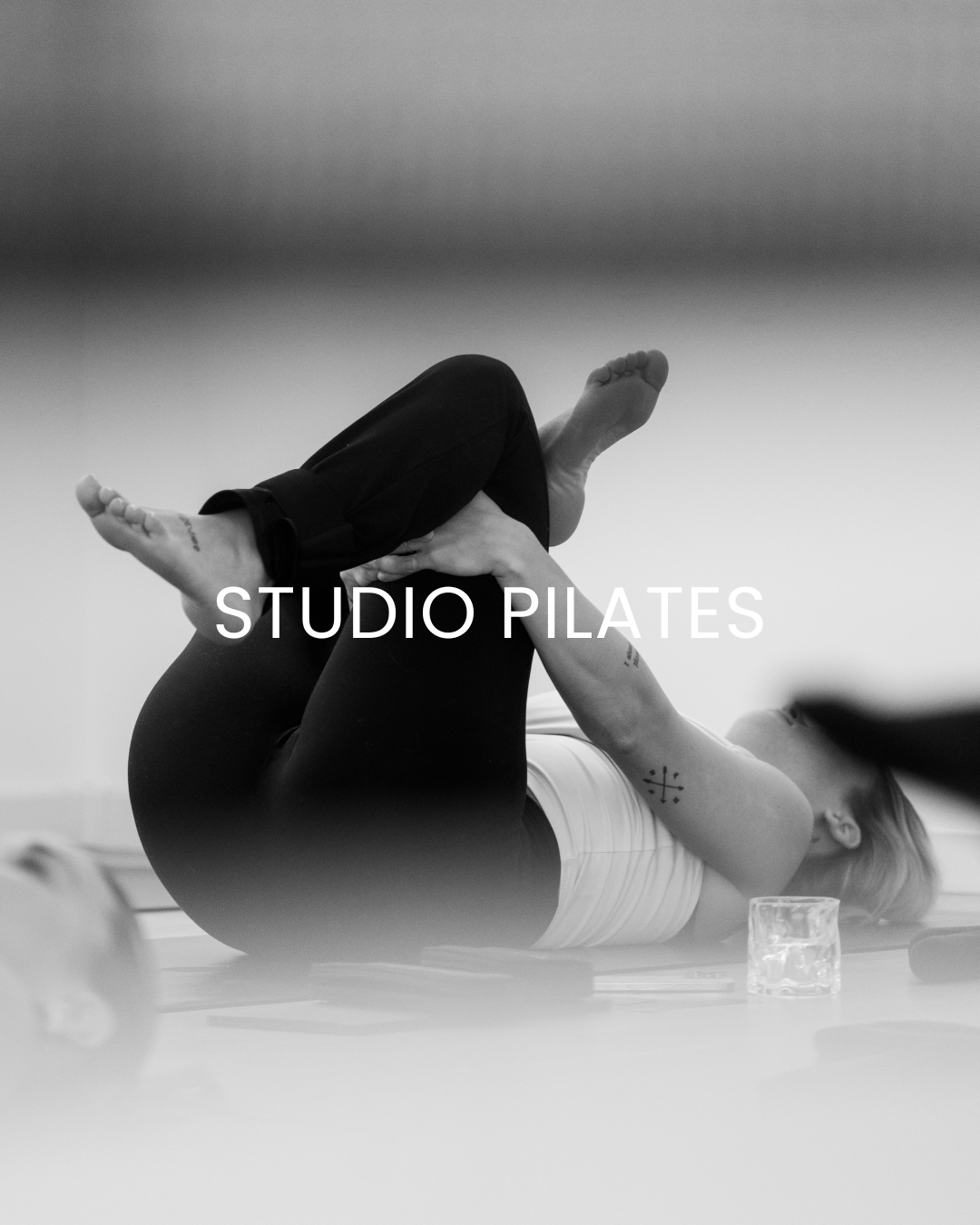 Et sort-hvidt foto af en kvinde, der laver pilates i SELF LOVE CLUB studie.