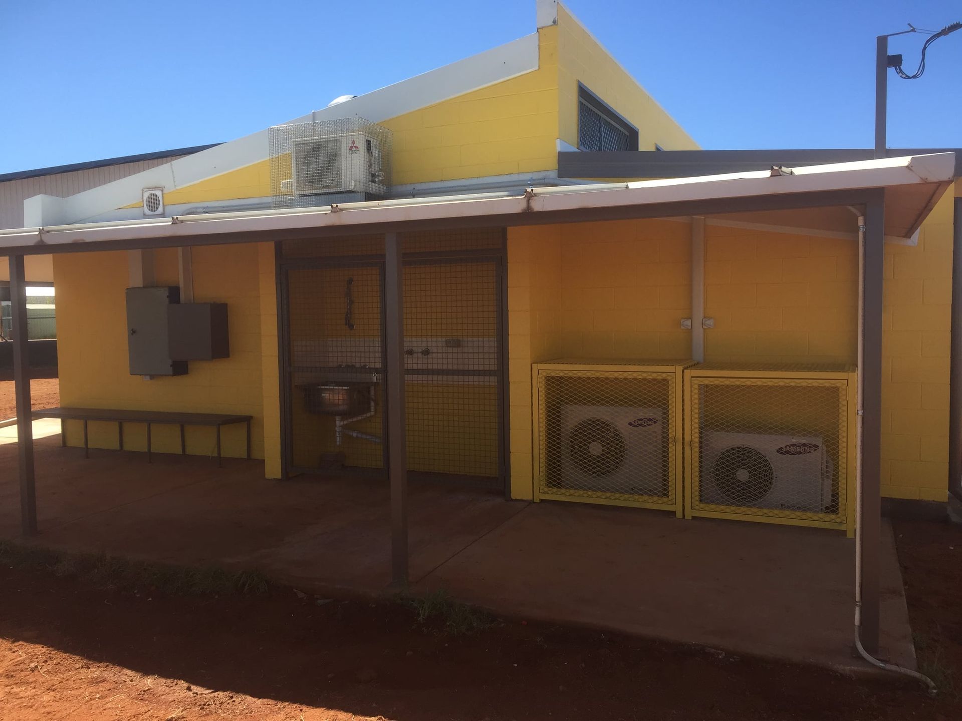 A Yellow Building With Two Air Conditioners On The Side β Bullant Building In Ciccone, NT