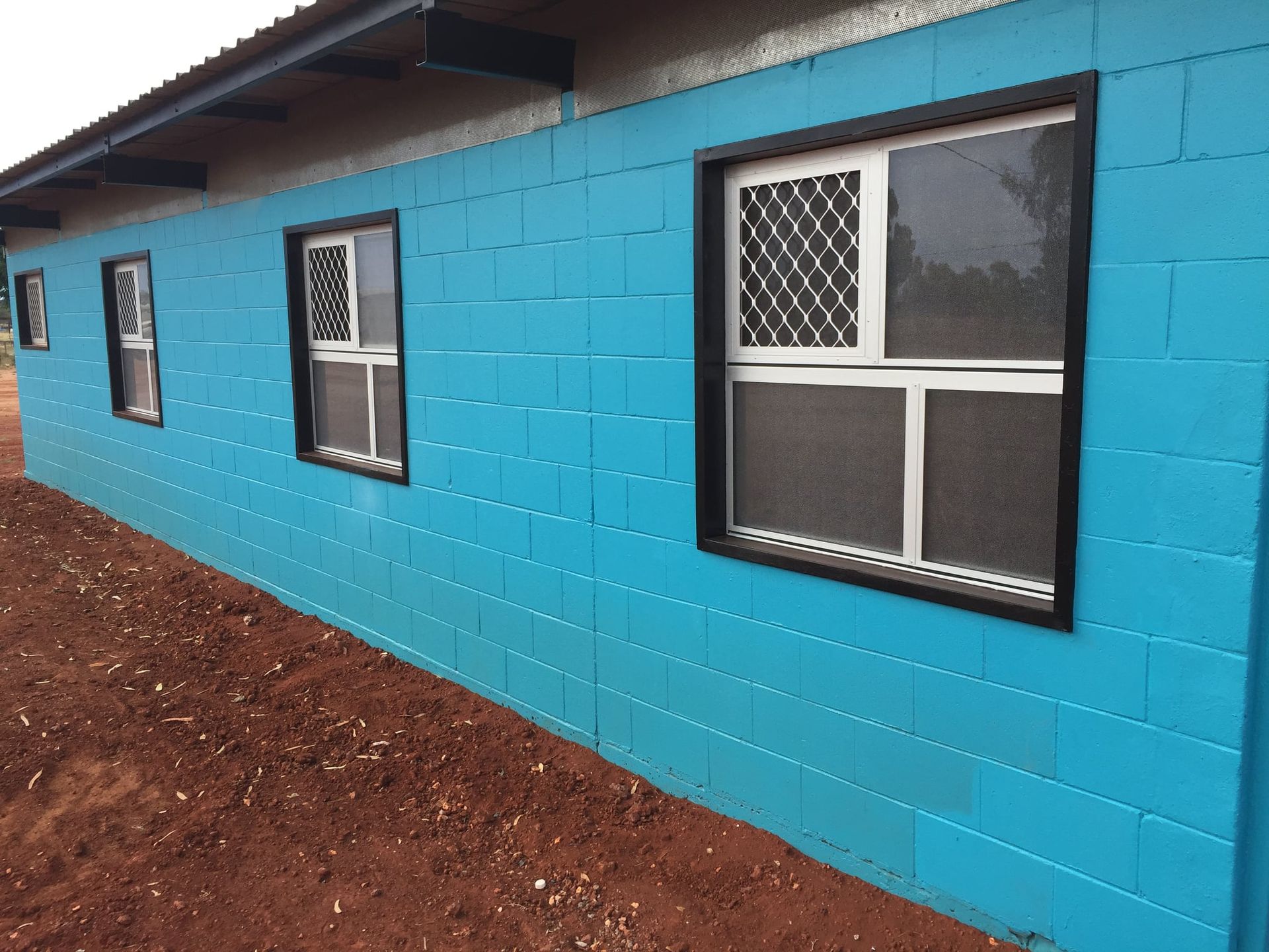 A Blue Brick Wall With A Row Of Windows — Bullant Building In Ciccone, NT