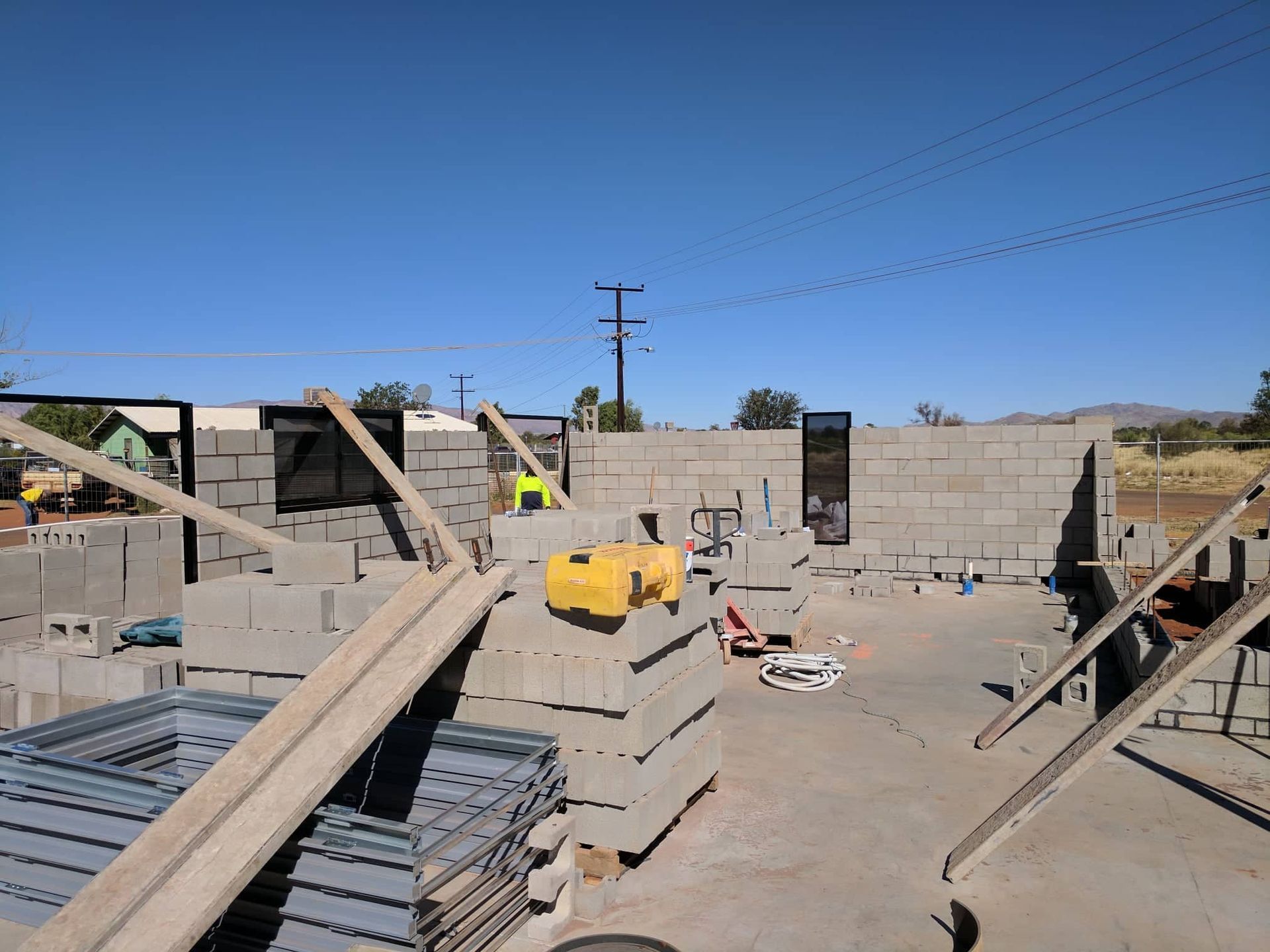 A construction site with a lot of bricks and a yellow machine — Bullant Building In Ciccone, NT