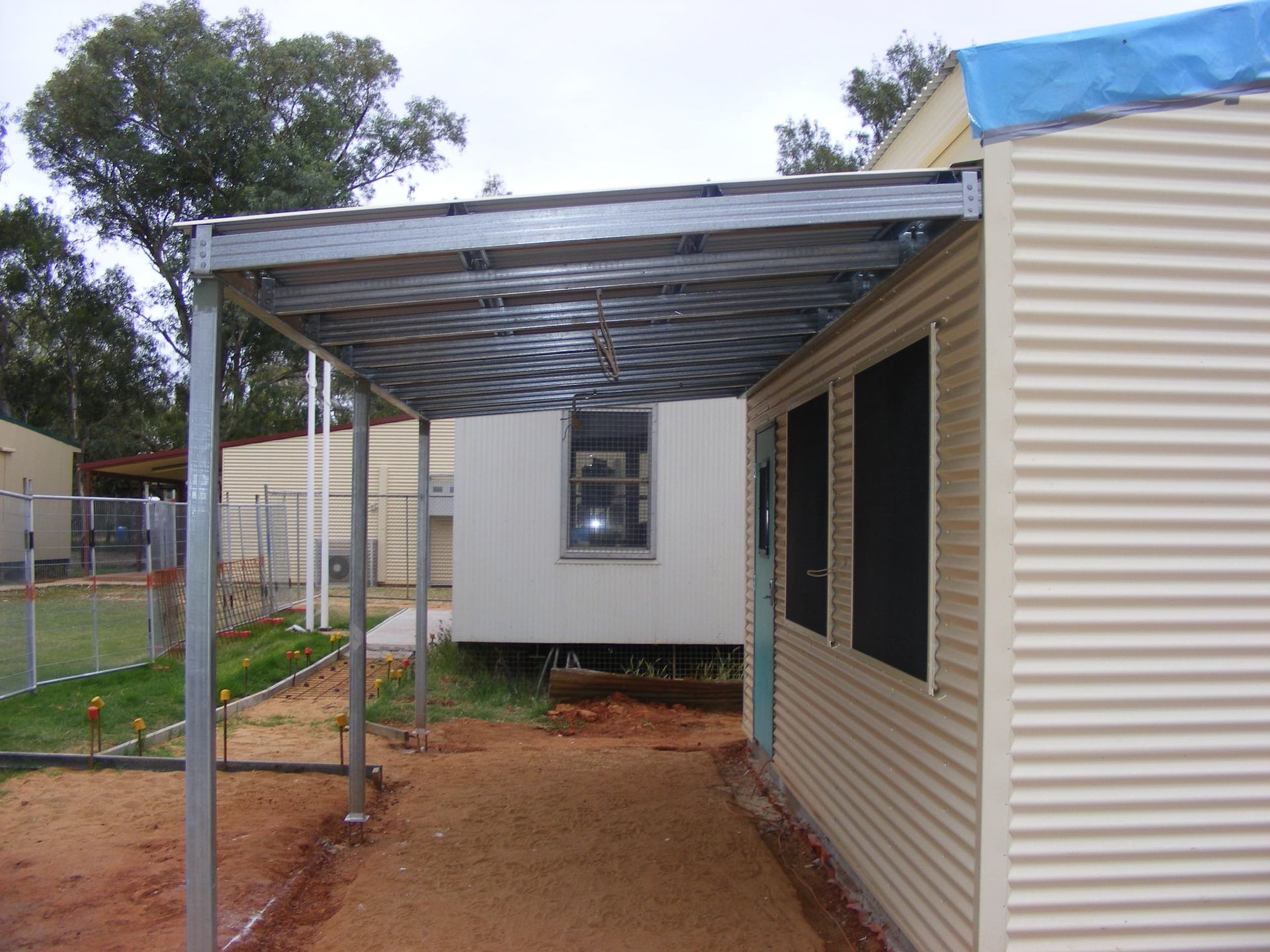 A White Building With A Blue Tarp On Top Of It β Bullant Building In Ciccone, NT