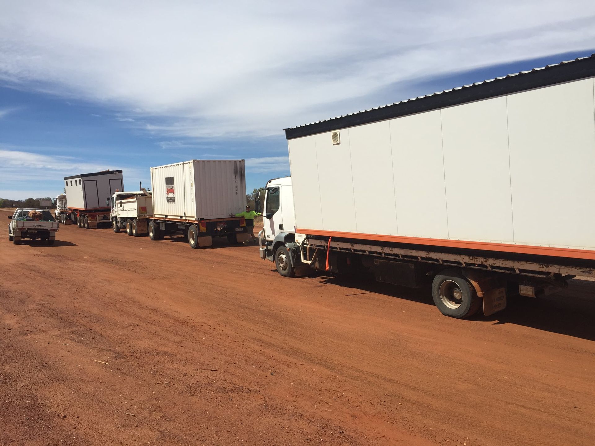 A Row Of Trucks Are Parked On A Dirt Road — Bullant Building In Ciccone, NT