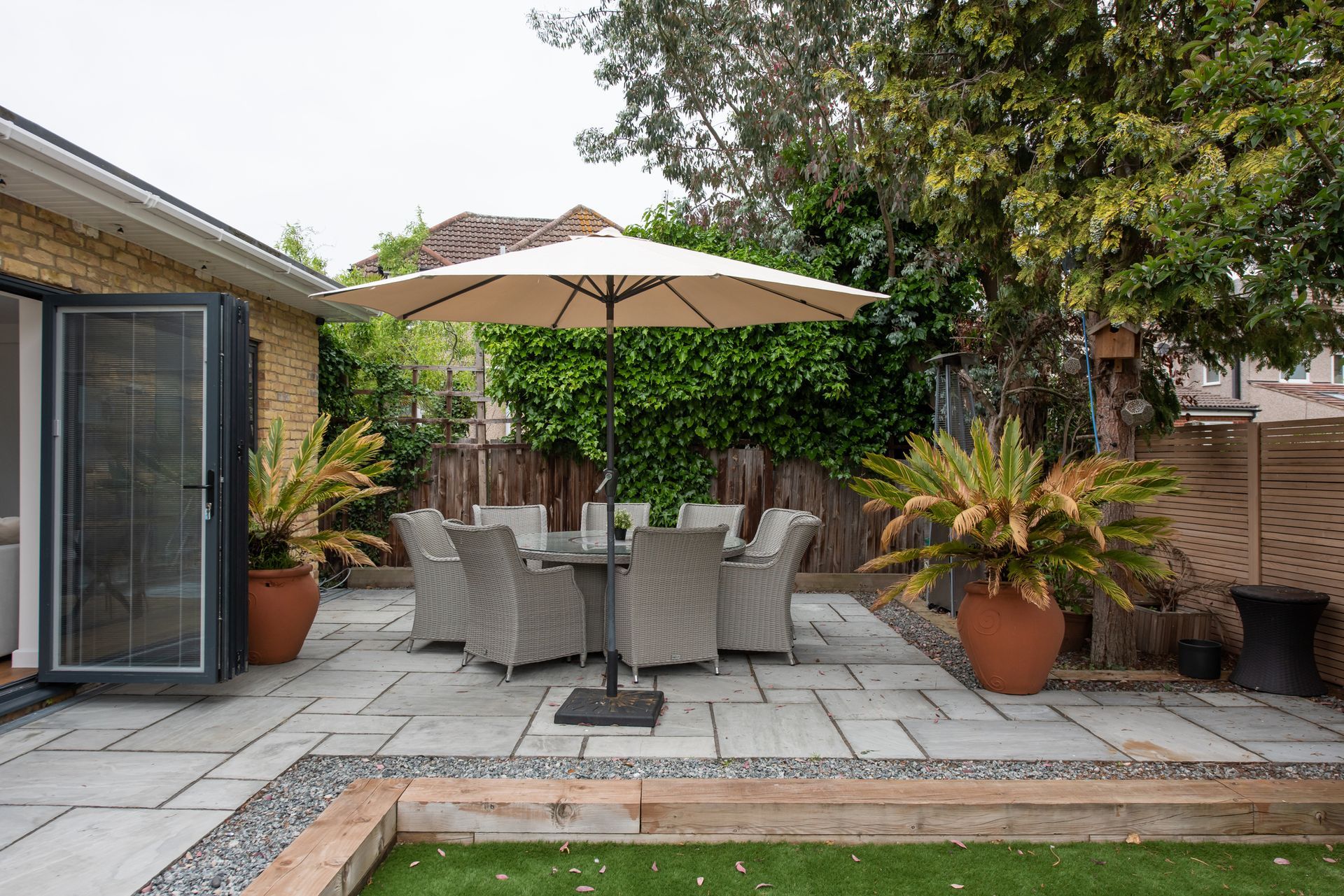 A patio with a table and chairs under an umbrella.