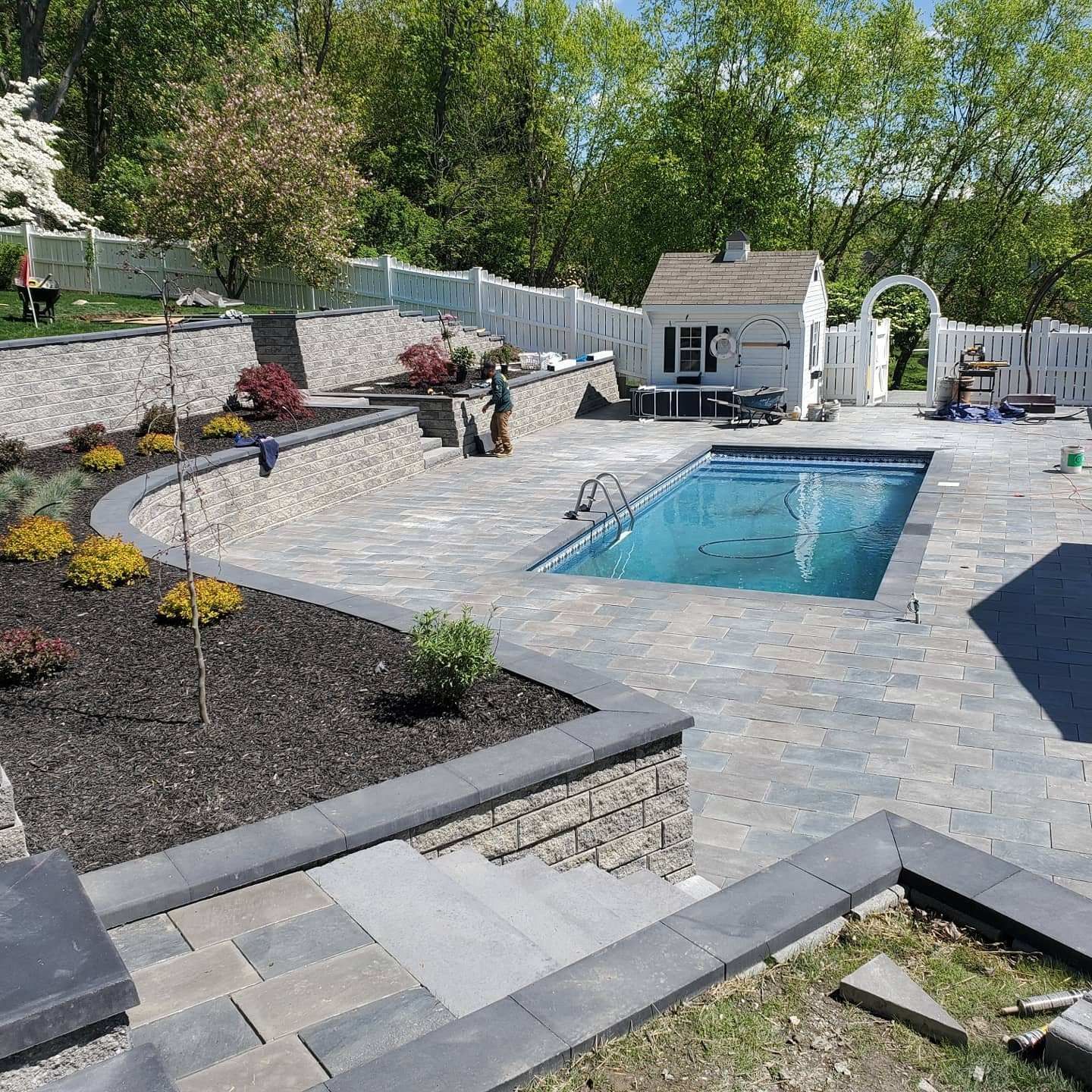A stone walkway surrounded by flowers and plants in a garden.