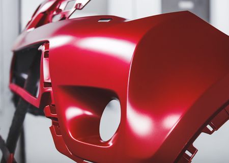 A close up of a red bumper on a car.