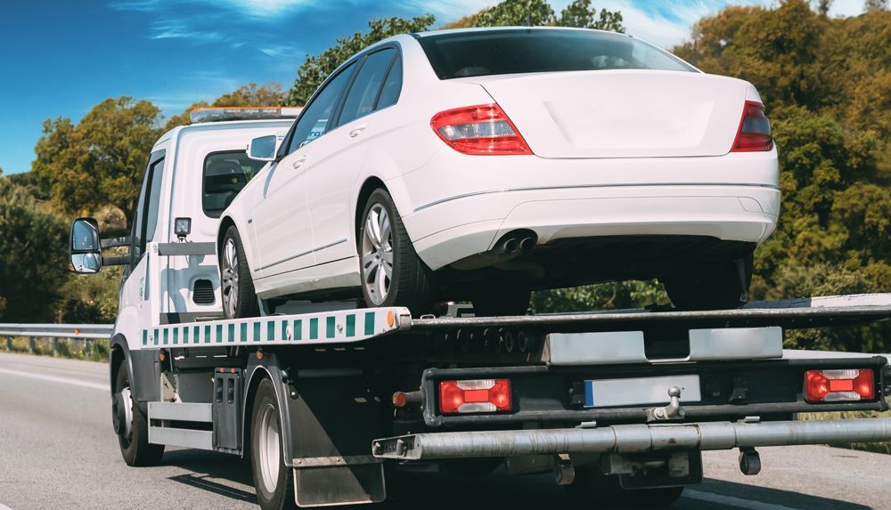 A car is being towed by a tow truck.