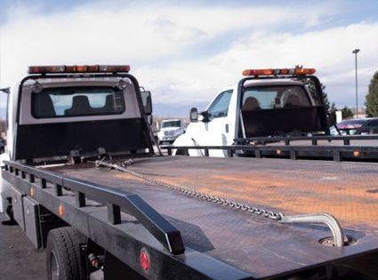 Two tow trucks are parked next to each other in a parking lot.