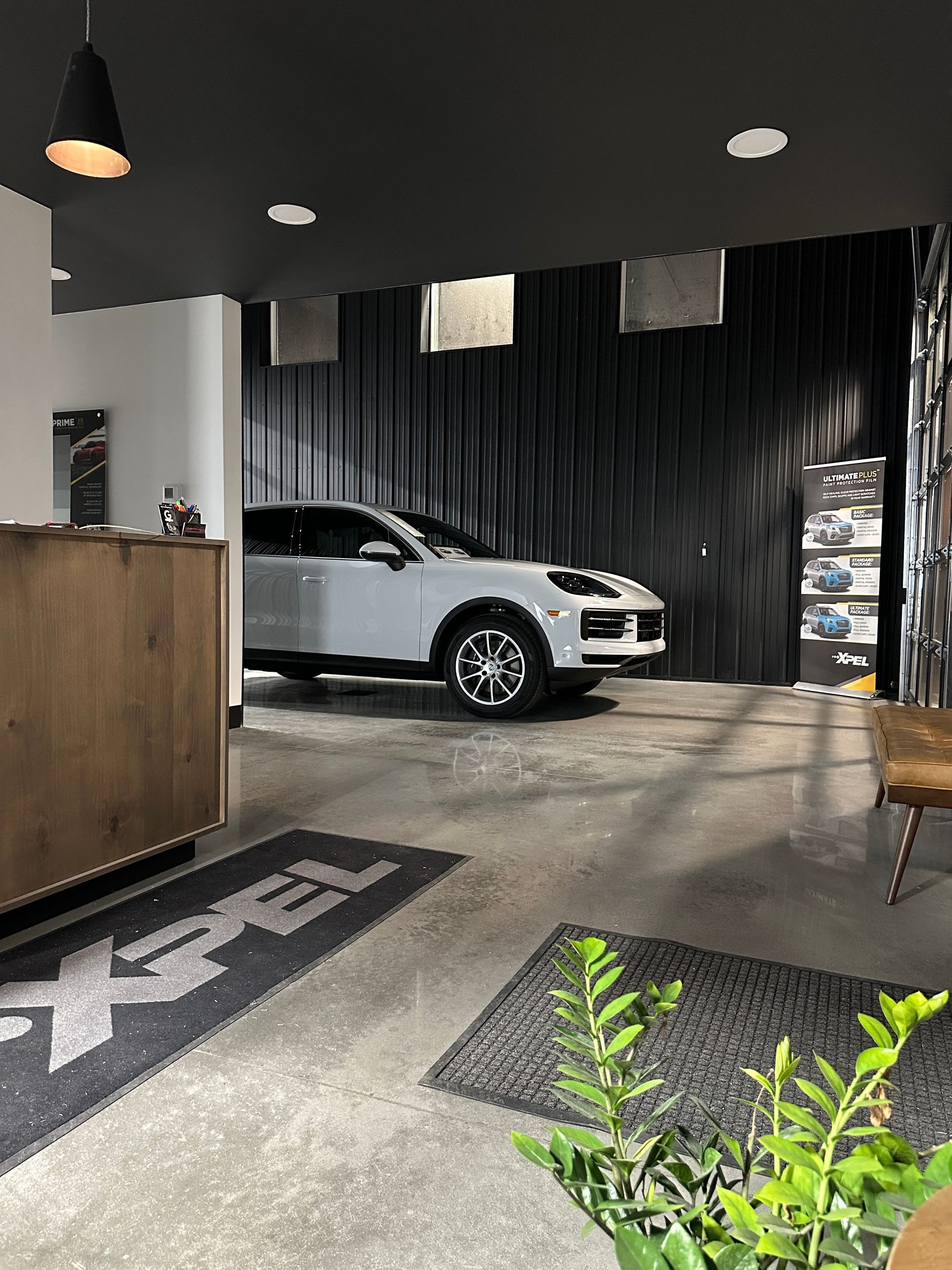 A person is cleaning a blue car with an orange towel