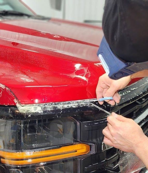 A person is applying tinted glass to a car window.