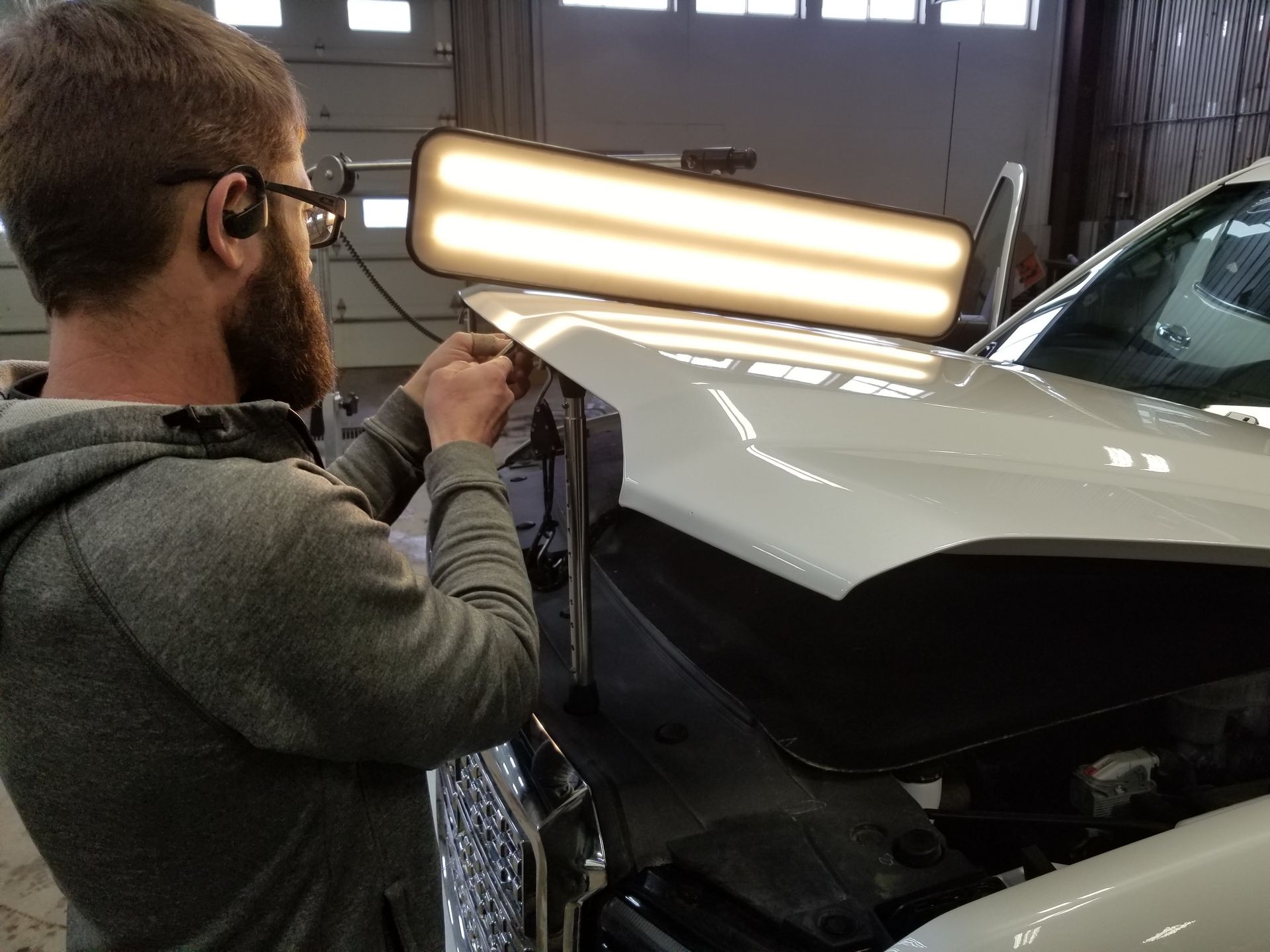 A man is working on a car in a garage.