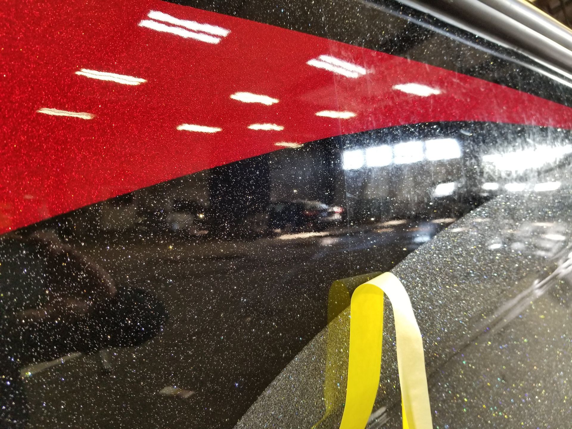 A red and black car with a yellow tape on it