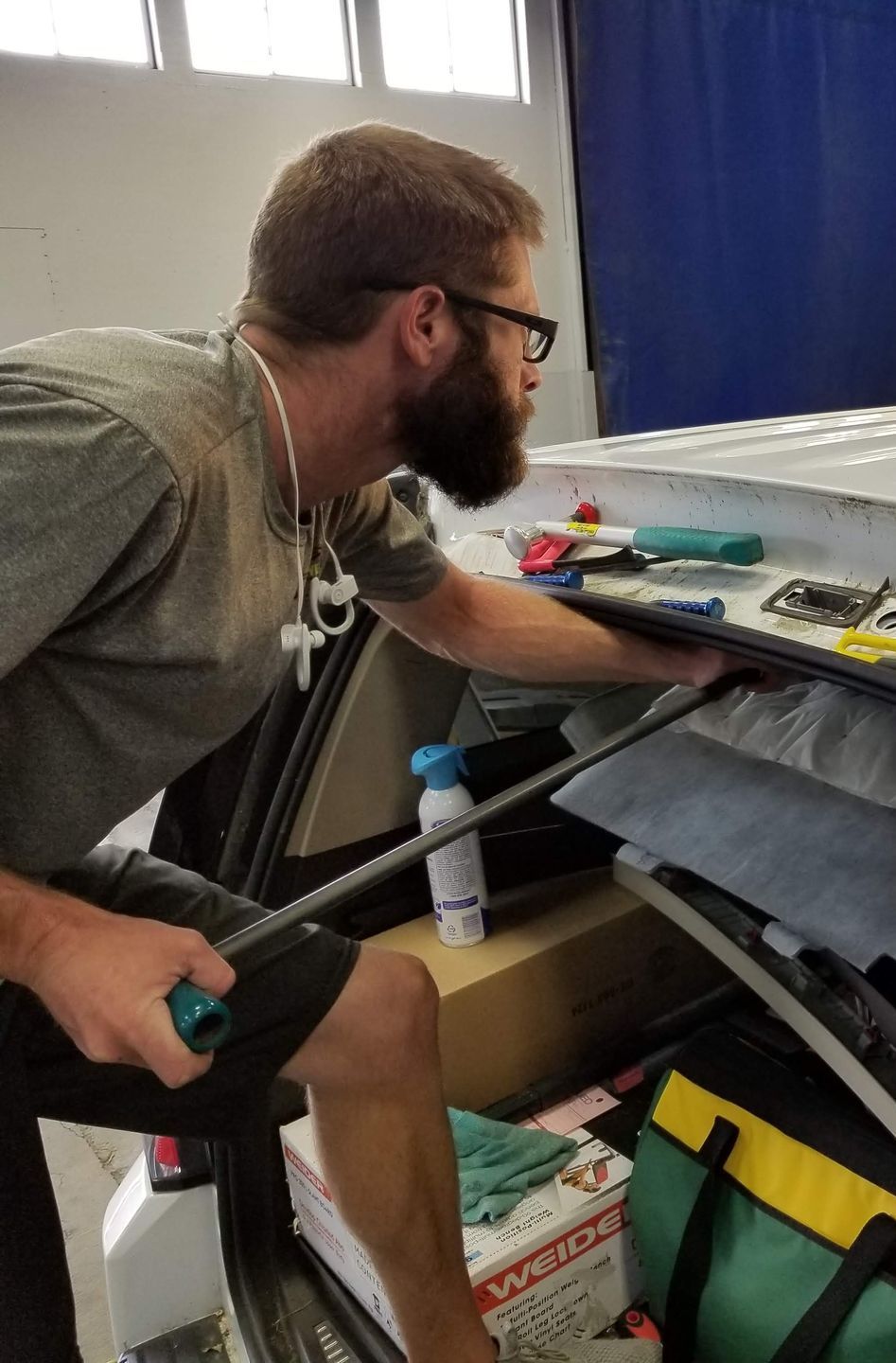 A person is applying tinted glass to a car window.