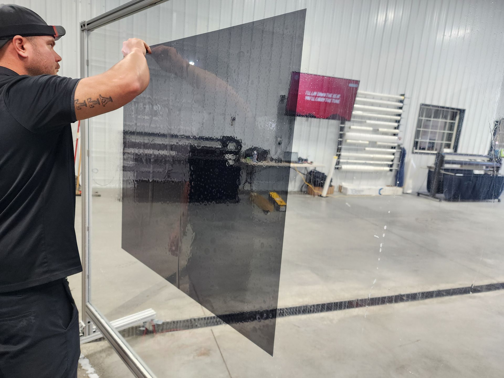 A person is applying tinted glass to a car windshield.