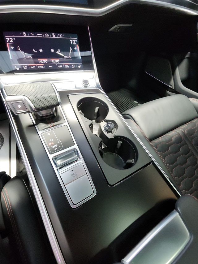 A person is applying a clear film to the hood of a car.