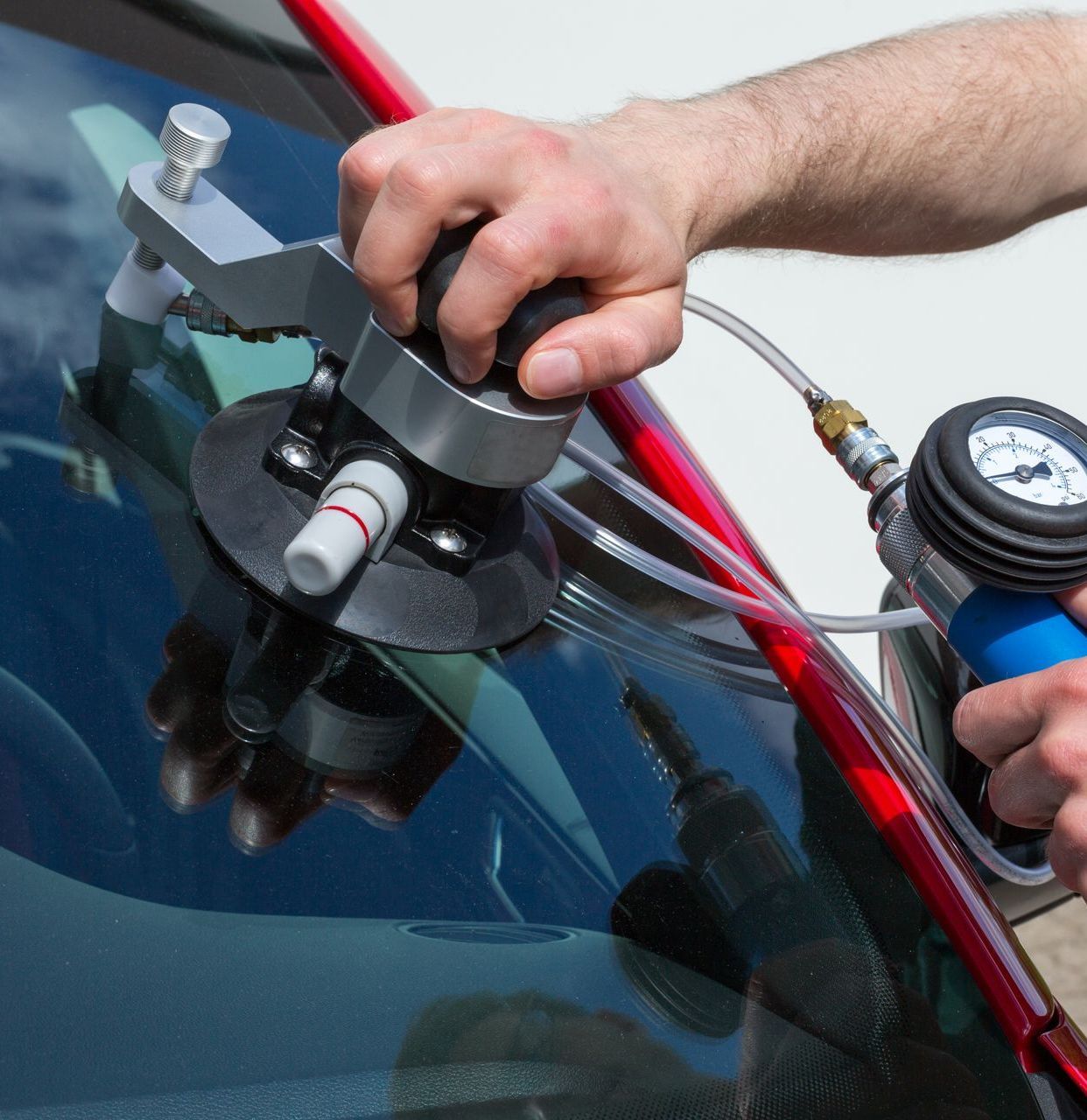 A man is repairing a windshield with a machine