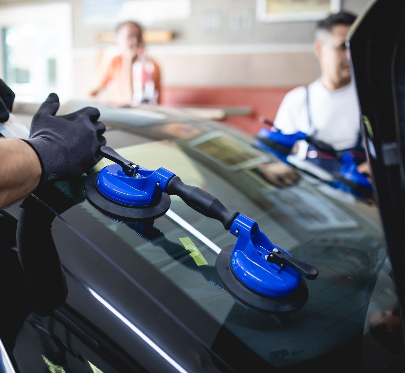 A person is applying tinted glass to a car window.