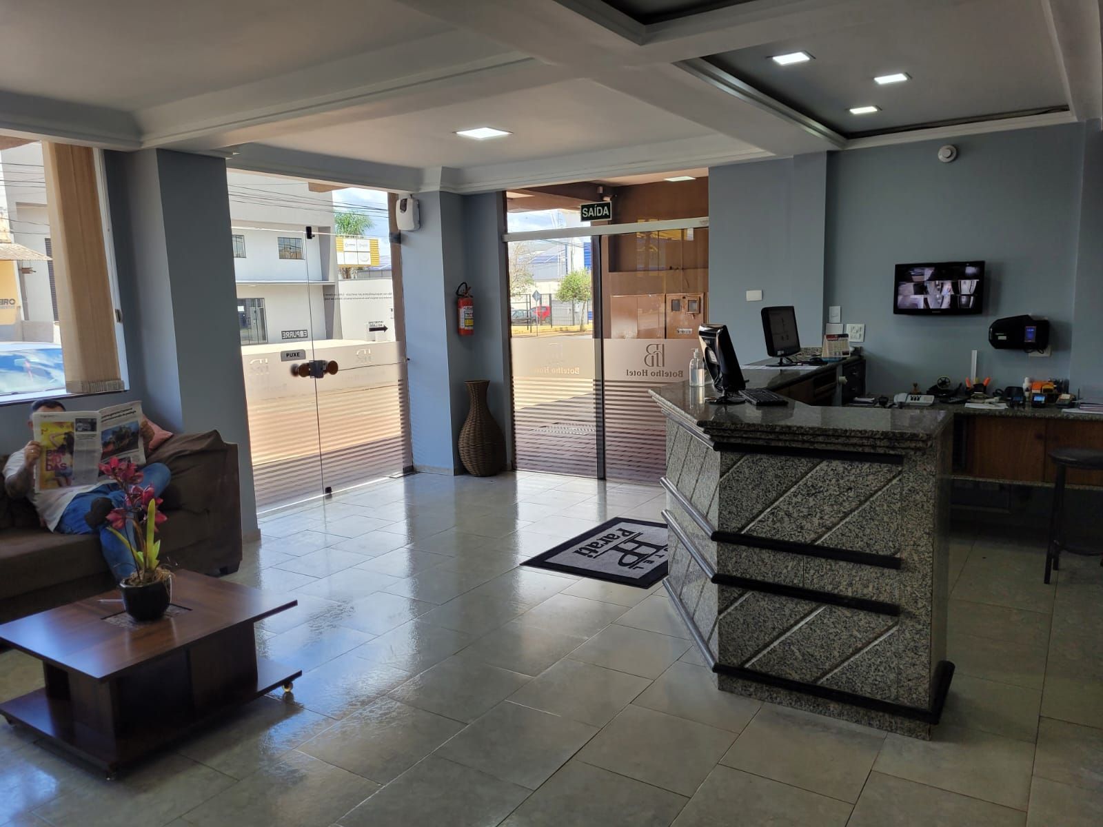 Um lobby de hotel com um sofá e uma mesa.