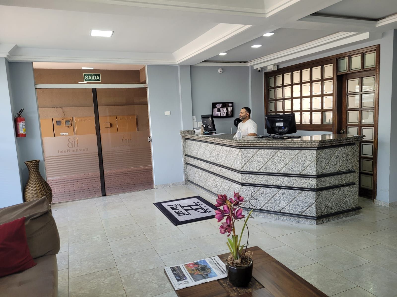 Um homem está de pé em um balcão no saguão de um hotel.