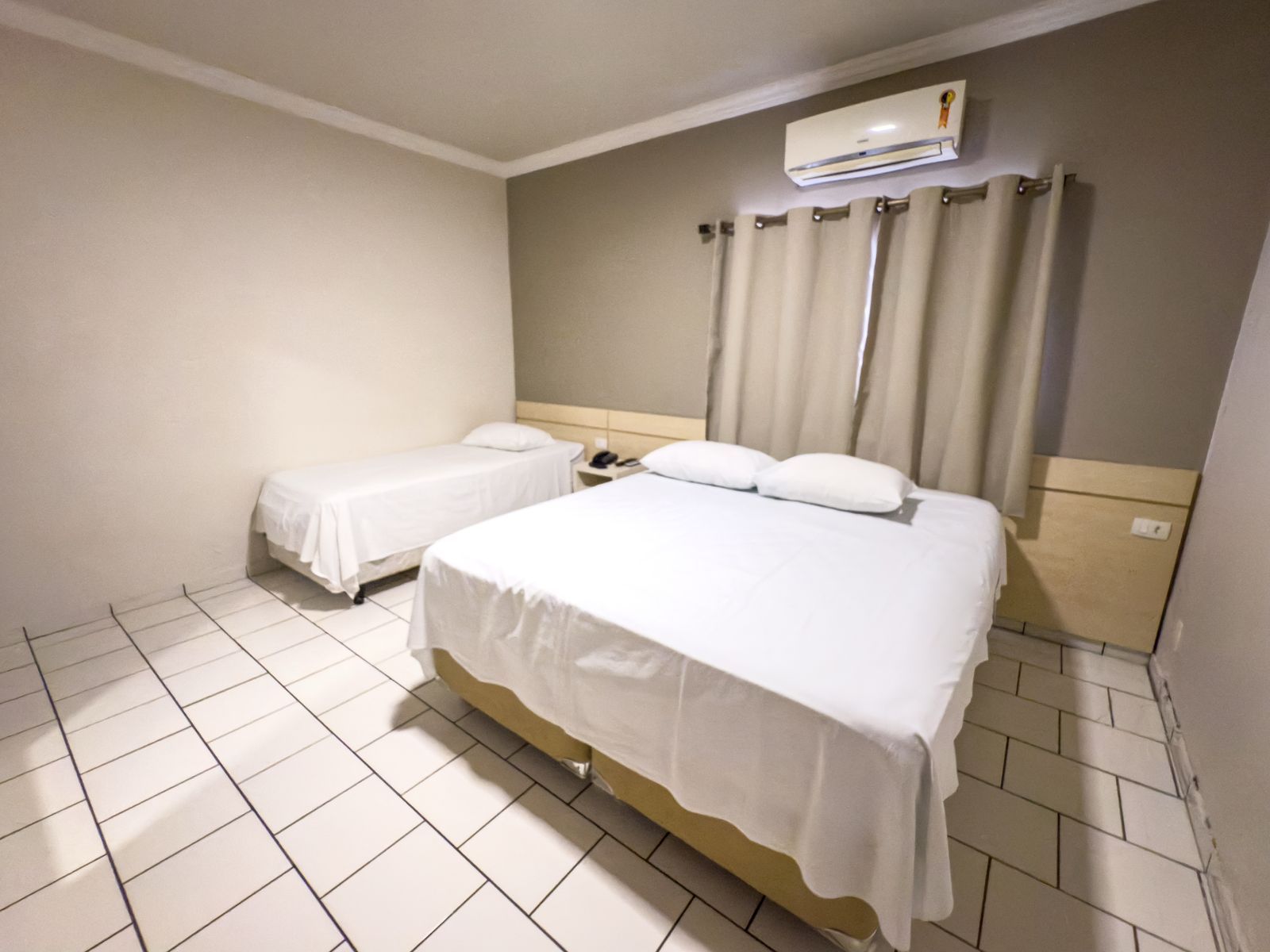 Um quarto de hotel com duas camas e ar condicionado.