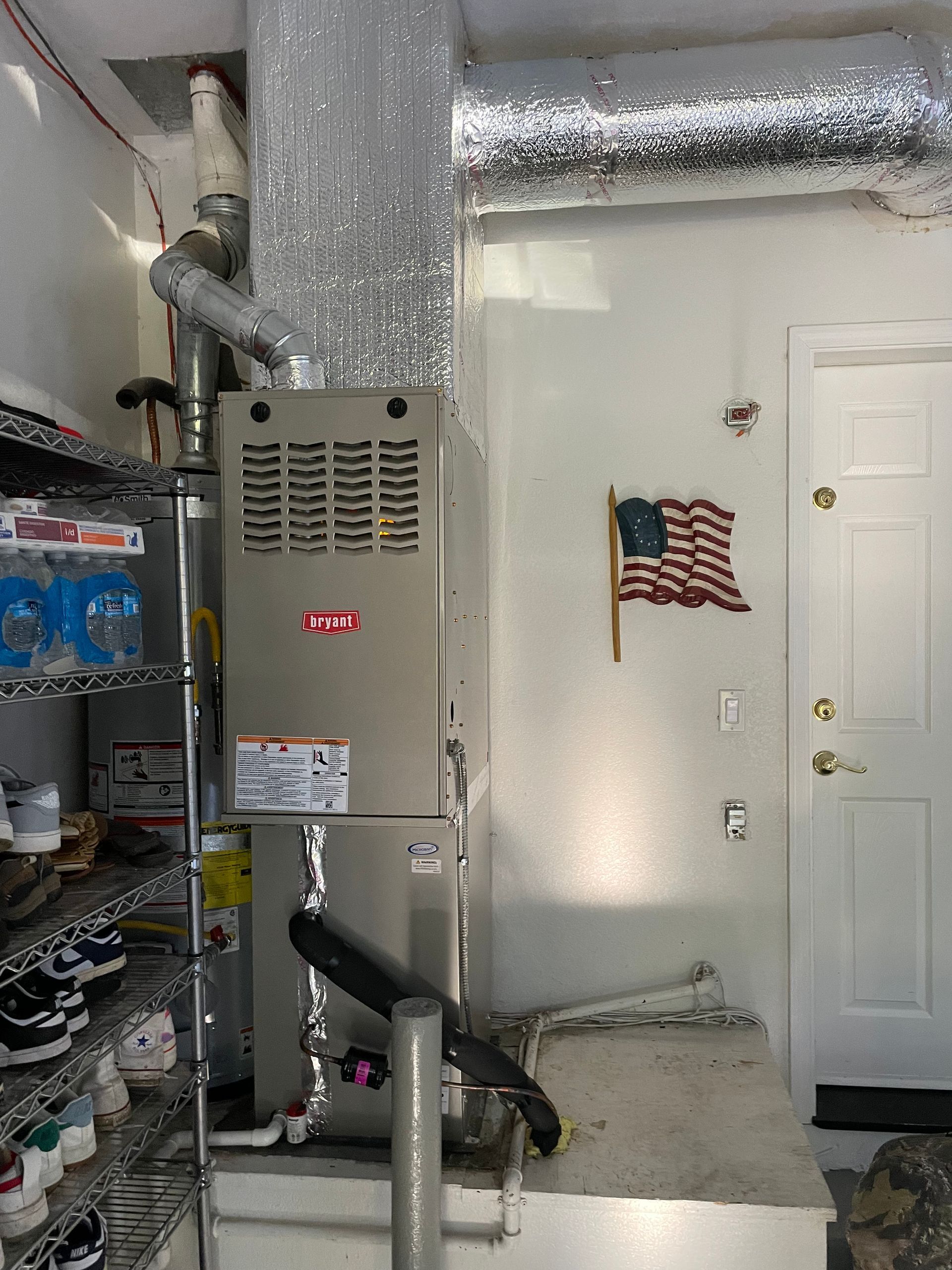A heating and cooling system in a garage with an american flag on the wall.