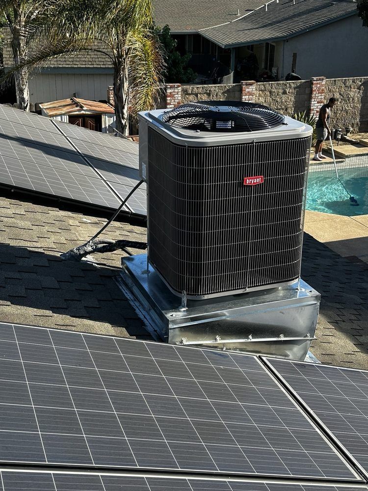 A black air conditioner is sitting on top of a roof next to a pool | Heating & Airflow