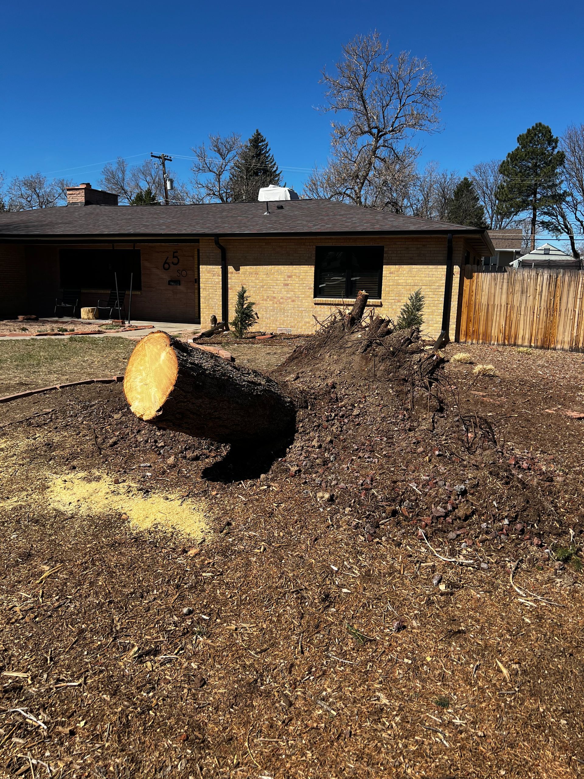 A man in an orange shirt is standing next to a yellow machine.