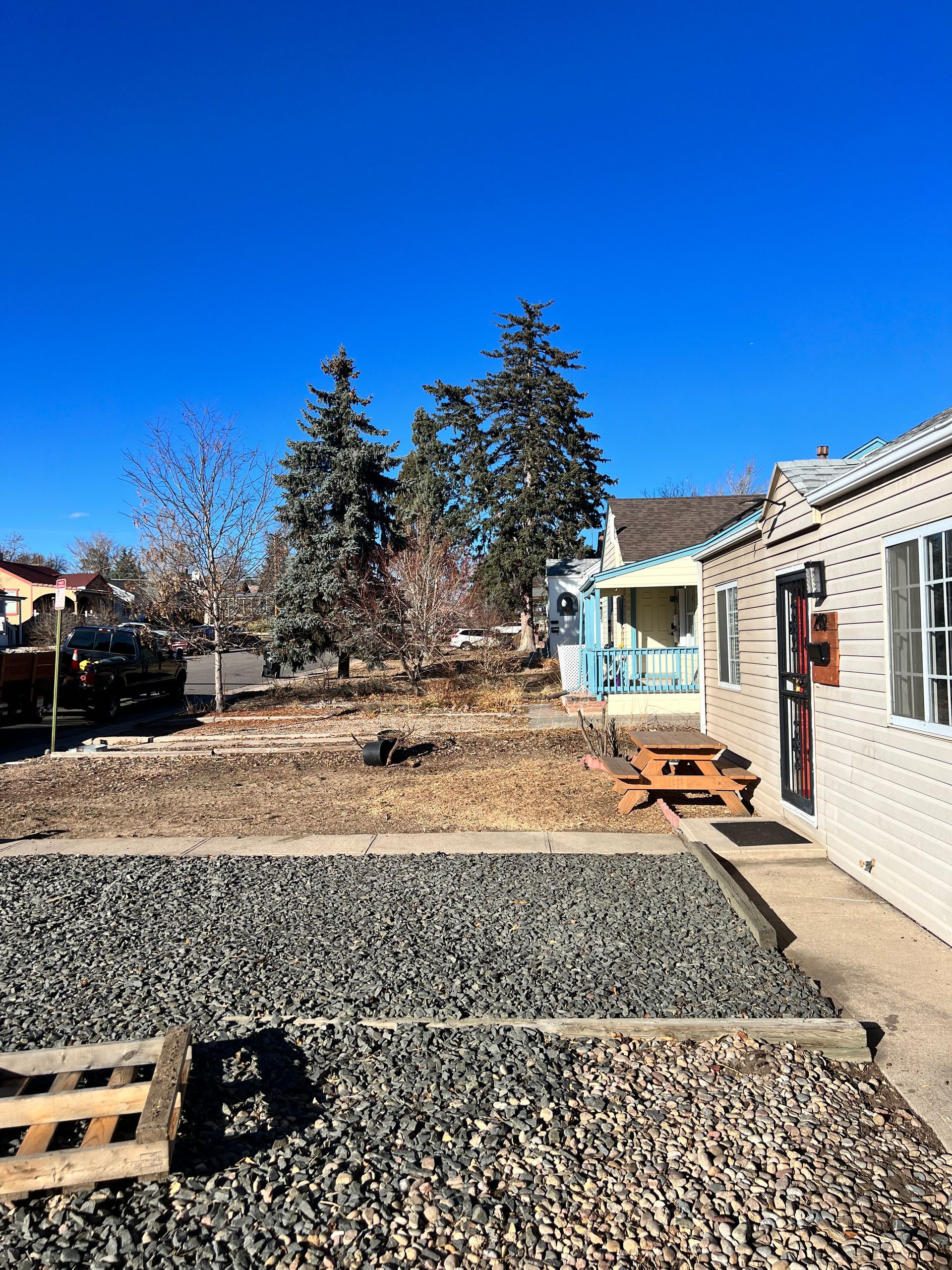 A bulldozer is moving dirt in a field with trees in the background.