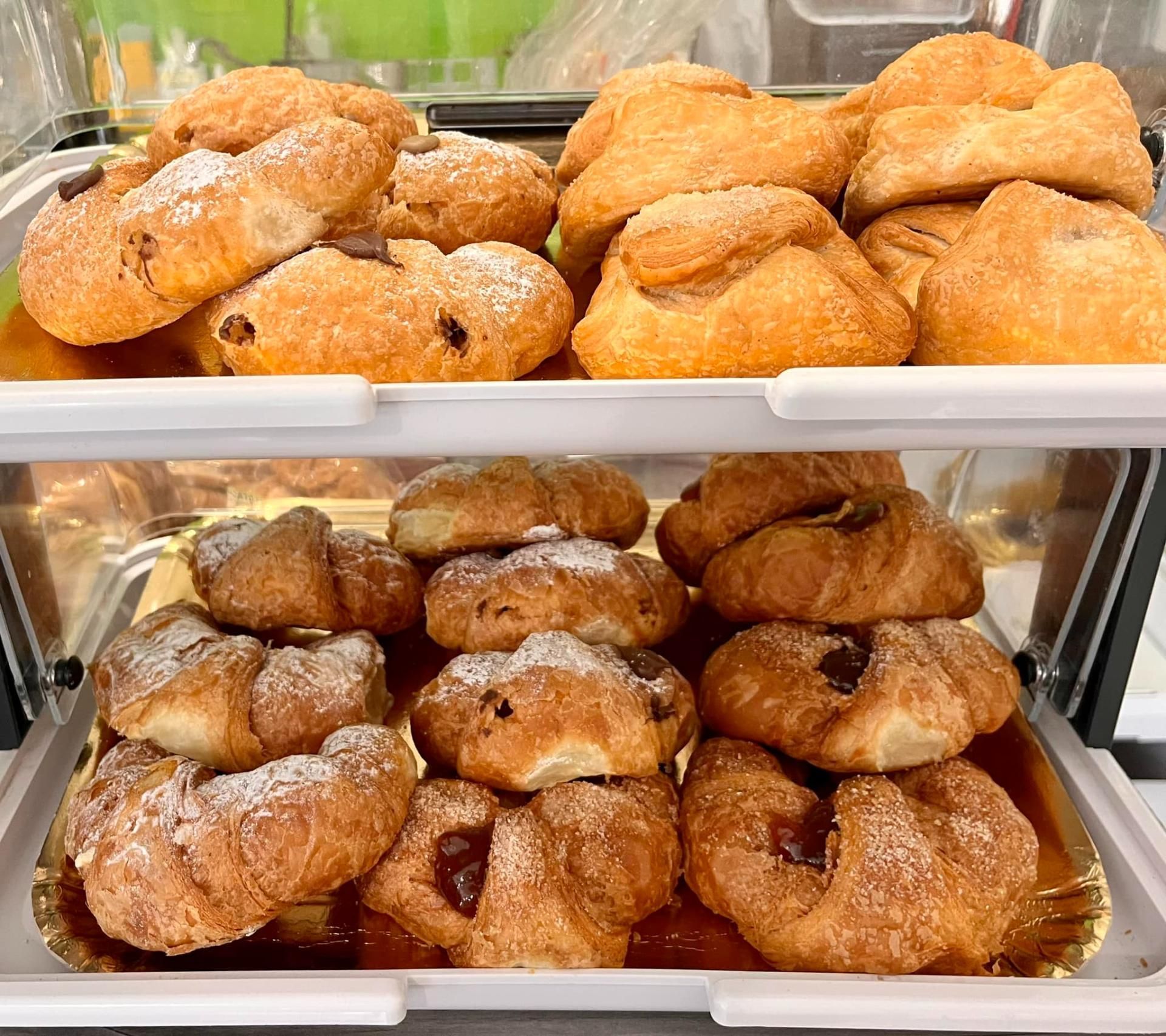 Una vetrina piena di una varietà di dolci e croissant.