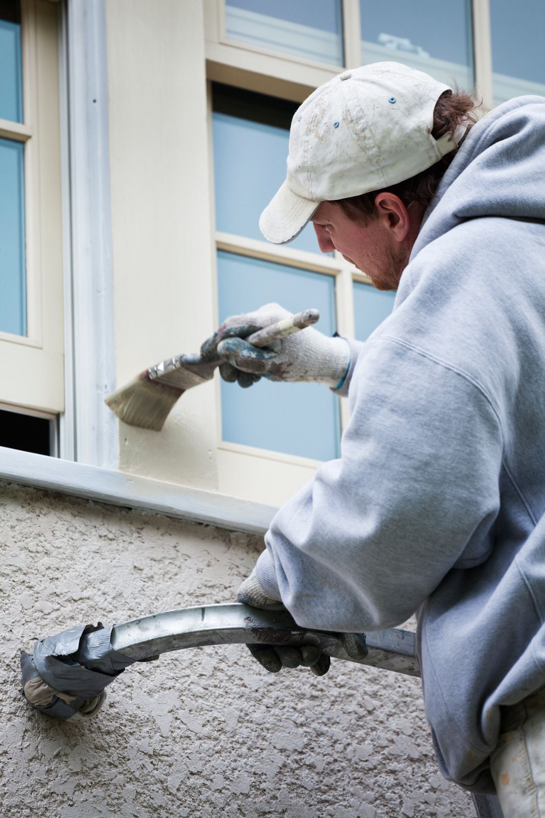 A man is painting a building with a brush.