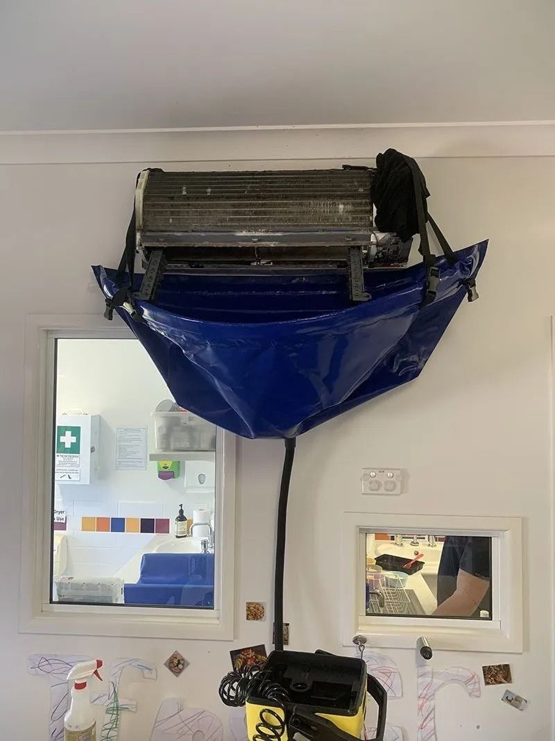 A Blue Bag is Hanging From the Ceiling of a Room Next to a Window — Northside Air Conditioning Services In Aspley, QLD