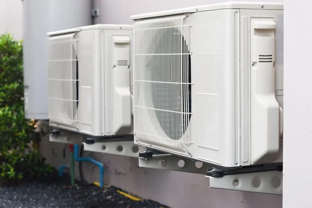 Three Air Conditioners Are Mounted on the Side of a Building — Northside Air Conditioning Services In Bridgeman Downs, QLD