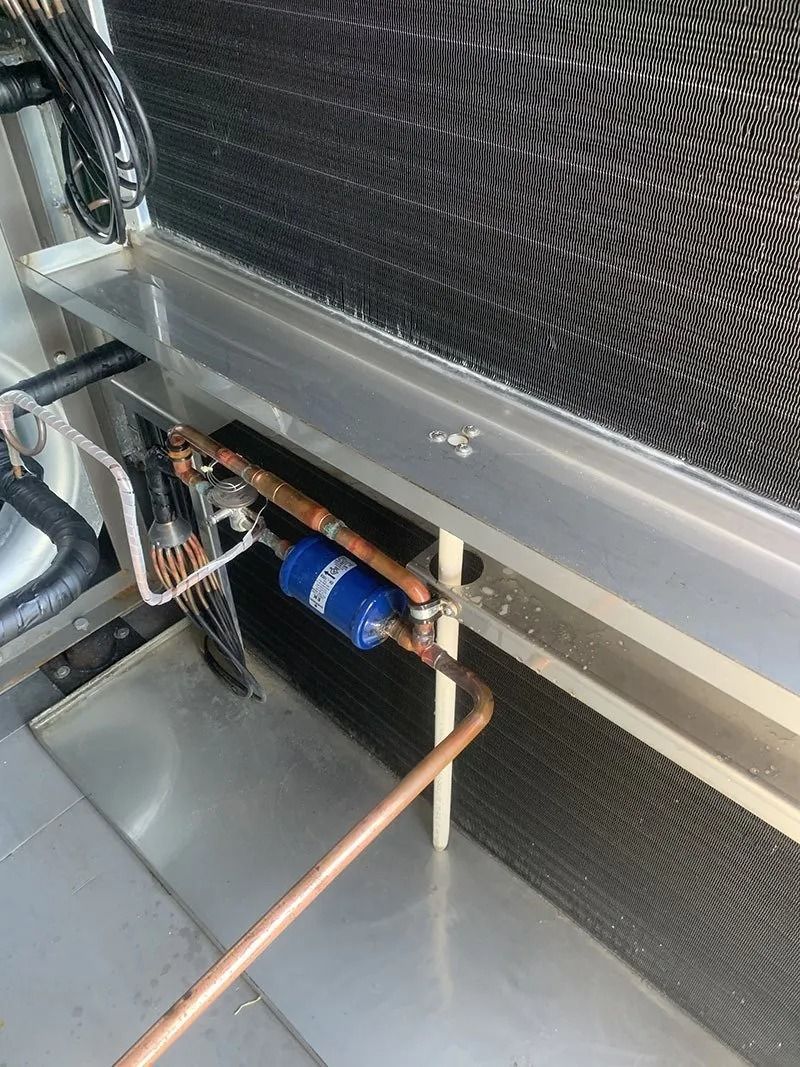 A Close Up of a Refrigerator With Copper Pipes Coming Out of It — Northside Air Conditioning Services In Hendra, QLD