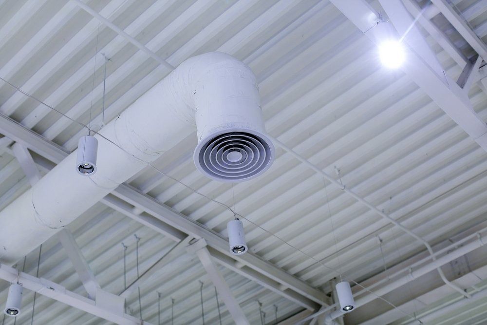 A White Air Duct is Hanging From the Ceiling of a Building — Northside Air Conditioning Services In Wavell Heights, QLD