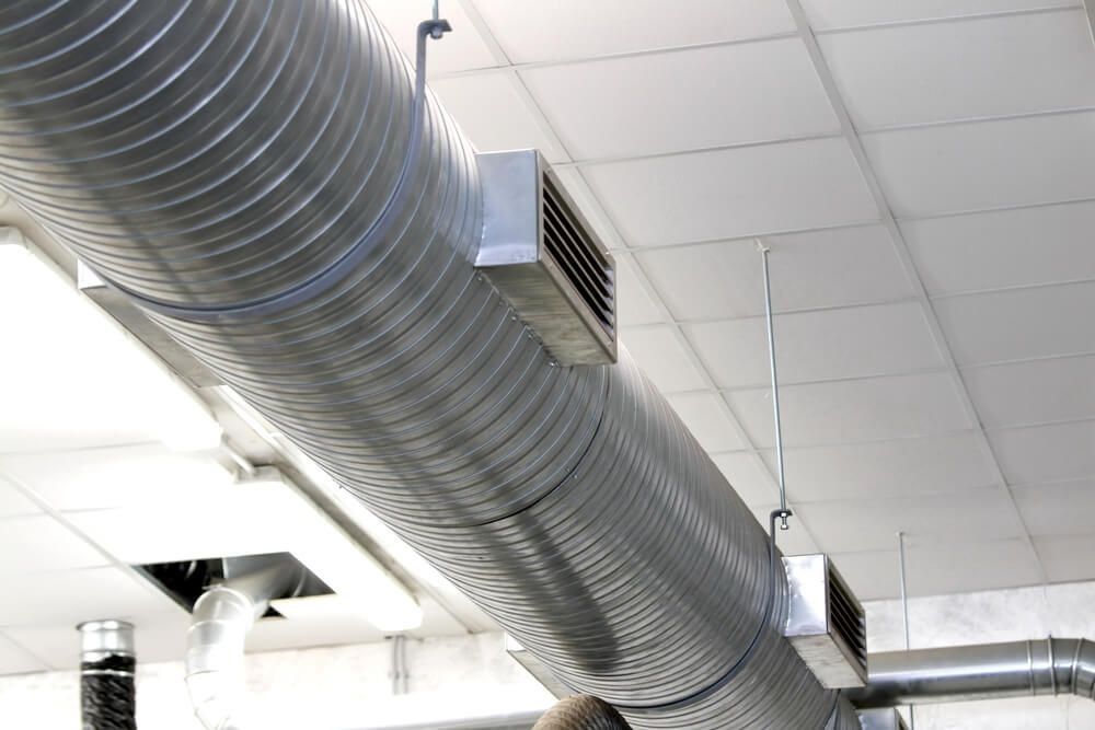A Large Metal Pipe is Hanging From the Ceiling of a Building — Northside Air Conditioning Services In McDowall, QLD