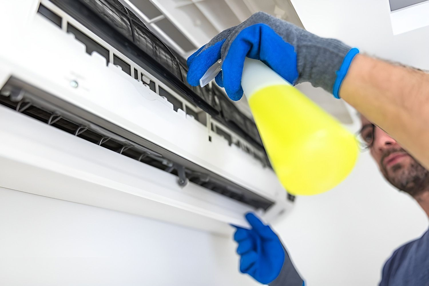 Person In Blue Gloves Cleaning An Air Conditioner