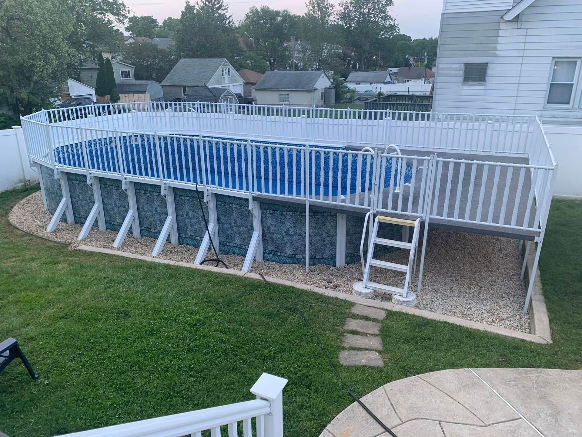 A large swimming pool is sitting in the backyard of a house.
