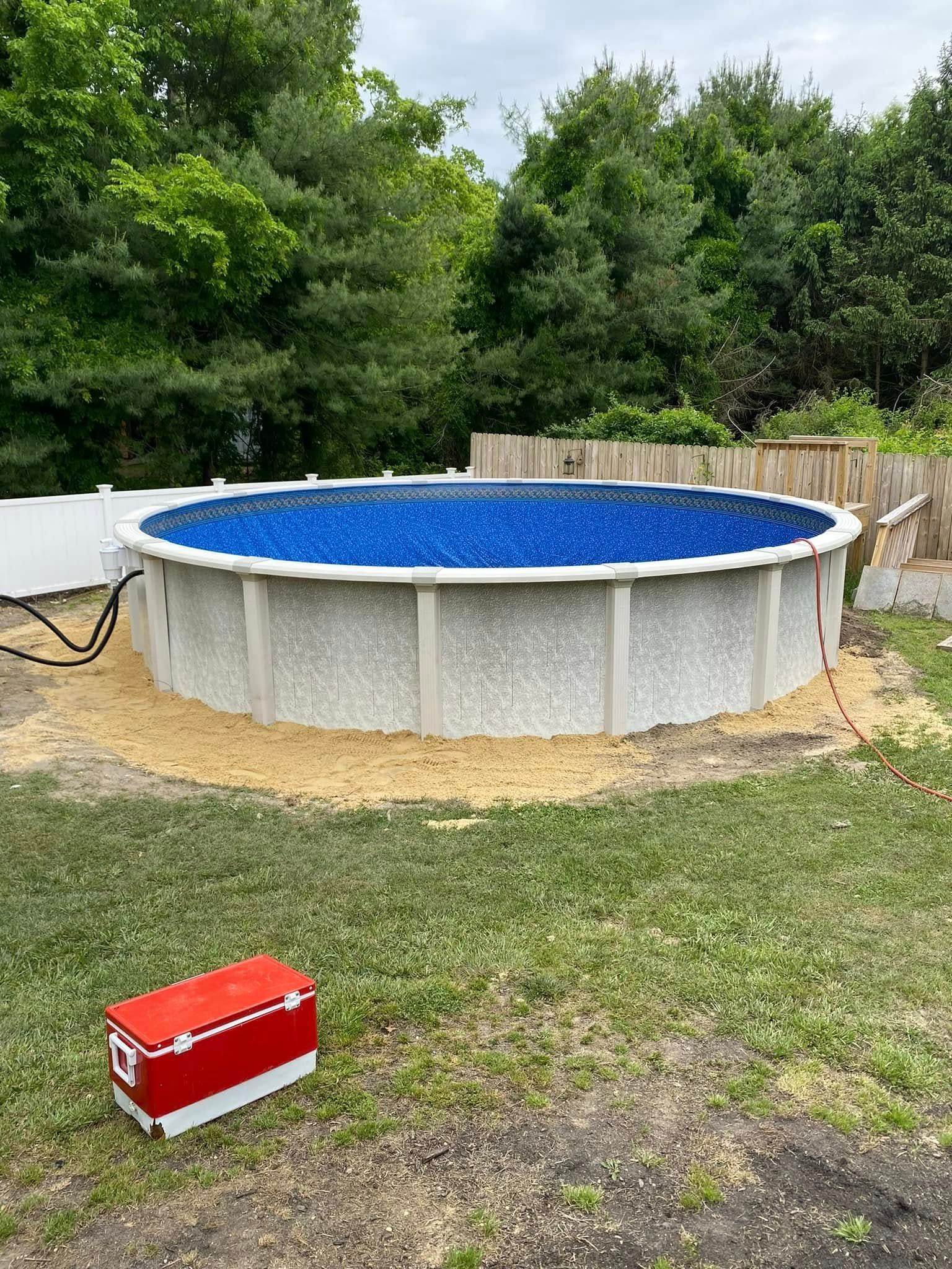 A large swimming pool is being built in a backyard.