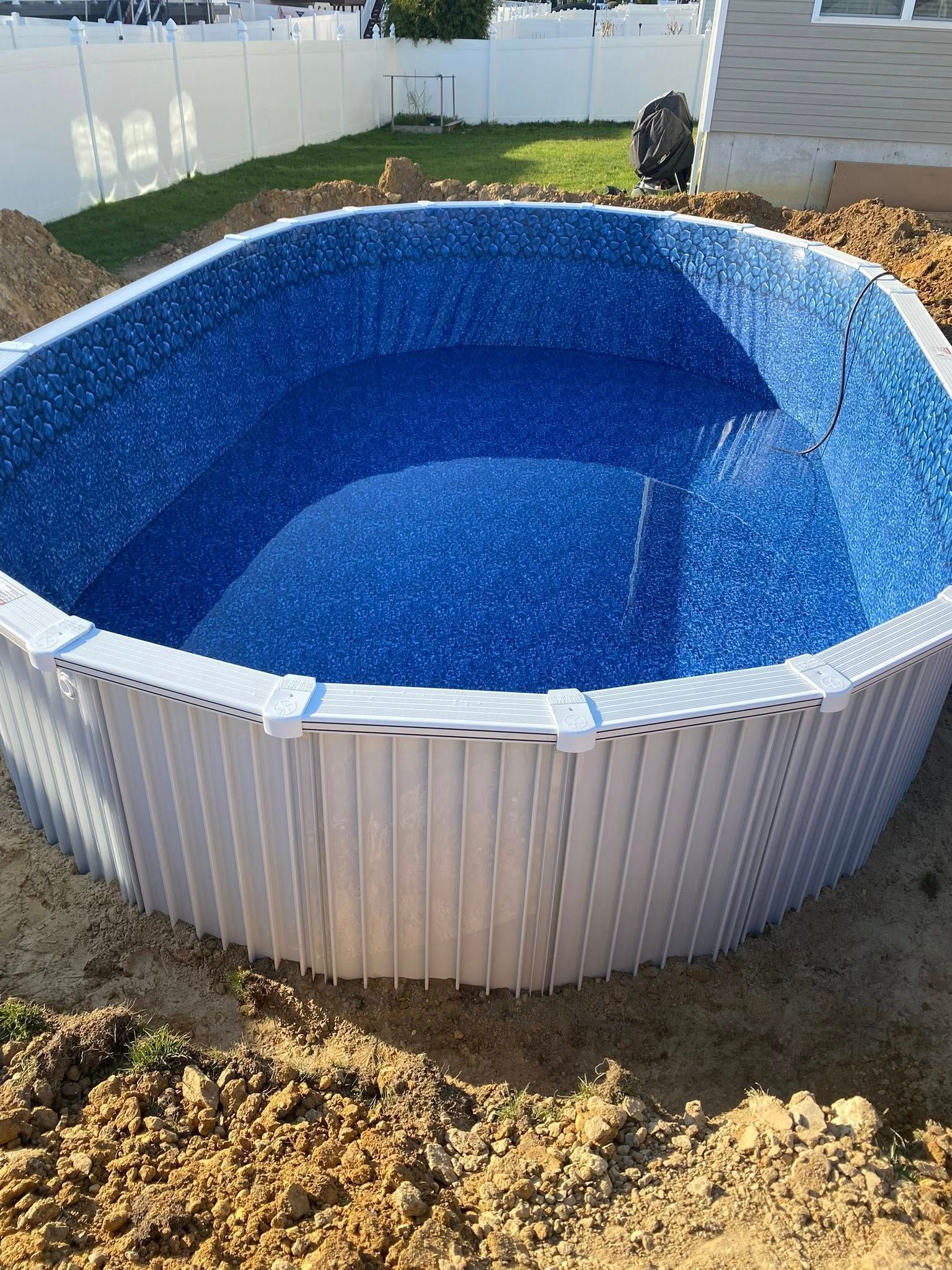 A large swimming pool is being built in a backyard.