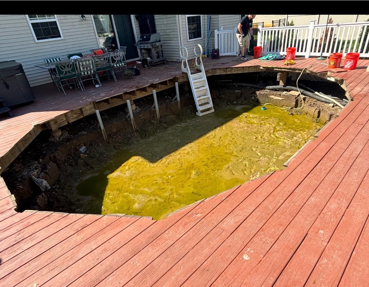 A large hole in a swimming pool on a wooden deck.