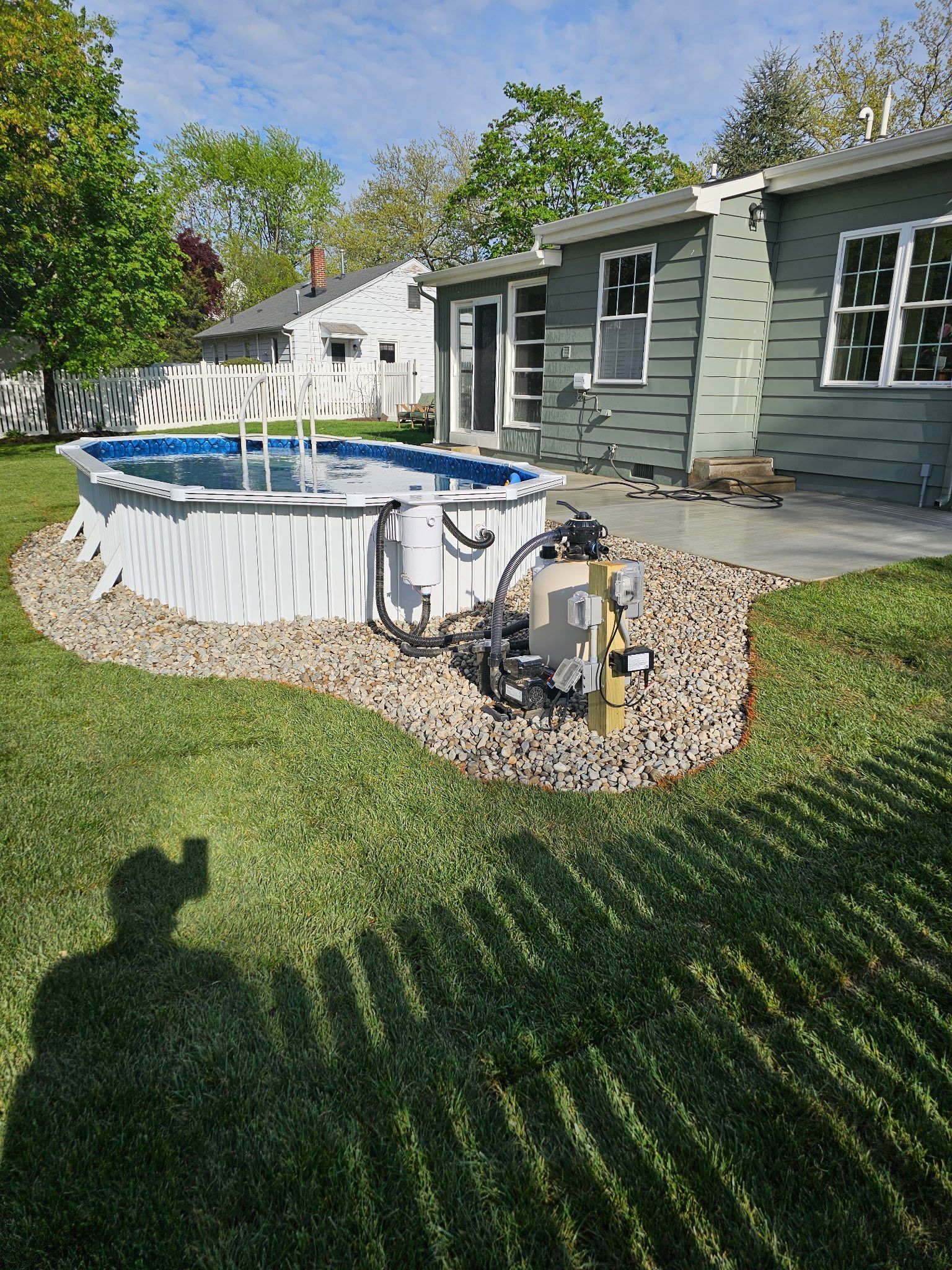 A swimming pool is in the backyard of a house.